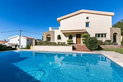 a villa with a swimming pool in front of a house at Villa Melia Athenian Riviera in Sounio