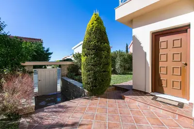 a front door of a house with a shrub at Villa Melia Athenian Riviera in Sounio