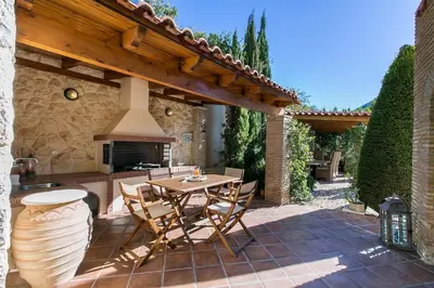 an outdoor patio with a table and a fireplace at Villa Melia Athenian Riviera in Sounio