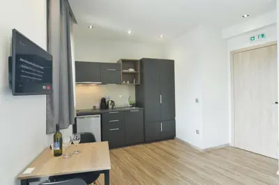 a kitchen with black cabinets and a table with wine glasses at Feel Athens Studios at Monastiraki in Athens