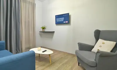 a living room with two chairs and a table and a tv at Feel Athens Studios at Monastiraki in Athens