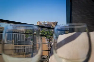 two wine glasses sitting on top of a balcony at Feel Athens Studios at Monastiraki in Athens