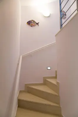 a staircase with a kite hanging on the wall at Porto Rafti view by Akroploro in Porto Rafti