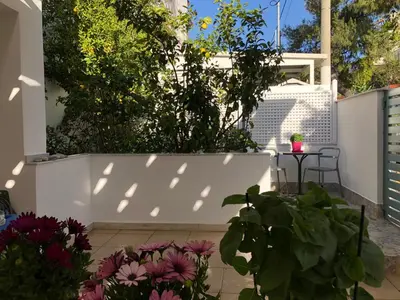 a patio with flowers and a white fence at Porto Rafti view by Akroploro in Porto Rafti