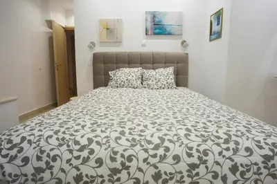 a bedroom with a bed with a black and white comforter at Porto Rafti view by Akroploro in Porto Rafti