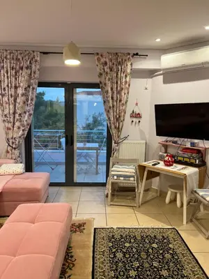 a living room with a couch and a tv at Porto Rafti view by Akroploro in Porto Rafti