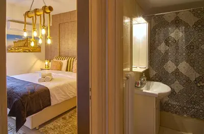 a bedroom with a bed and a sink and a mirror at Signature Athens Residence, 130 sqm, Near Metro in Athens