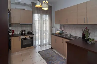 a kitchen with wooden cabinets and a sink and a window at Signature Athens Residence, 130 sqm, Near Metro in Athens