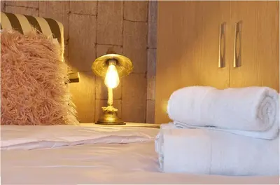 a bed with a lamp and towels on it at Signature Athens Residence, 130 sqm, Near Metro in Athens