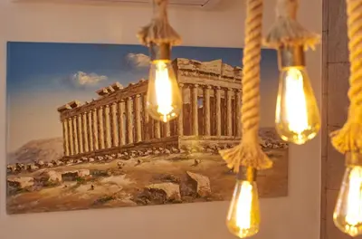 a painting of the acropolis hanging on a wall with lights at Signature Athens Residence, 130 sqm, Near Metro in Athens