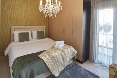 a bedroom with a large bed with a chandelier at Signature Athens Residence, 130 sqm, Near Metro in Athens