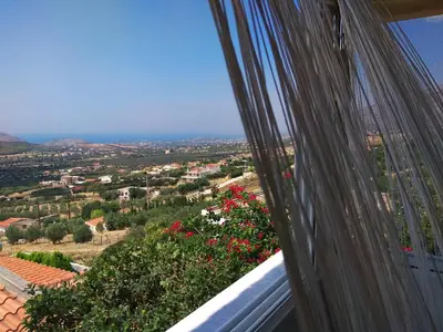 a view of a city from a balcony with flowers at Outstanding Panoramic View, 10΄ beach, 20΄ airport in Ólimbos
