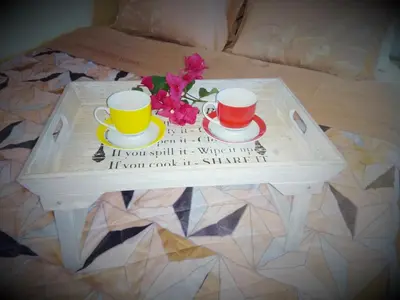 a table with two cups and flowers on a bed at Outstanding Panoramic View, 10΄ beach, 20΄ airport in Ólimbos