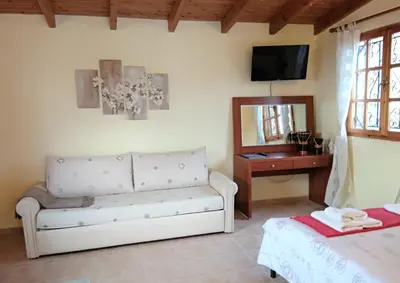 a living room with a couch and a mirror at Outstanding Panoramic View, 10΄ beach, 20΄ airport in Ólimbos
