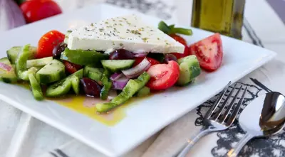 a white plate with a salad with cheese and vegetables at Outstanding Panoramic View, 10΄ beach, 20΄ airport in Ólimbos