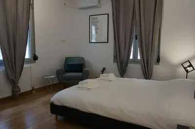 a bedroom with a large bed and a chair at Exarcheia House in Athens