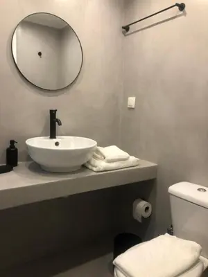 a white bathroom with a sink and a mirror at Exarcheia House in Athens