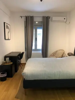 a bedroom with a bed and a desk and a window at Exarcheia House in Athens