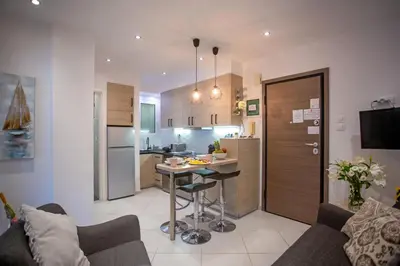 a kitchen and living room with a table in a room at Hadrian by Heloni Apartments in Athens