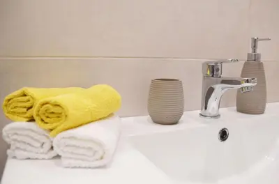 a bathroom sink with towels and a faucet at Hadrian by Heloni Apartments in Athens
