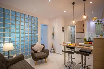 a living room with a kitchen with blue glass block walls at Hadrian by Heloni Apartments in Athens