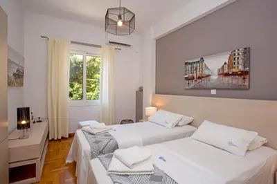 two beds in a room with two windows at Hadrian by Heloni Apartments in Athens