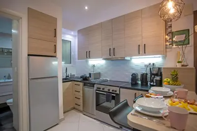 a kitchen with wooden cabinets and a table with plates on it at Hadrian by Heloni Apartments in Athens