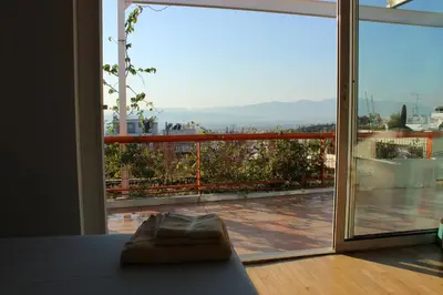 a room with a large window with a view of a balcony at Acropolis view penthouse in Athens