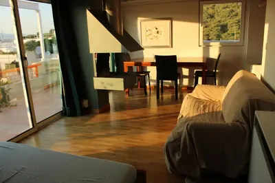 a living room with a couch and a dining room table at Acropolis view penthouse in Athens