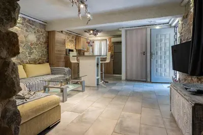 a living room with a couch and a tv at Stone House in Athens