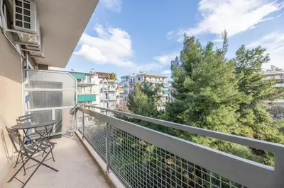 a balcony with a table and chairs and buildings at Top sightseeing 3rd floor studio on a paved road! in Athens