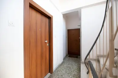 a hallway with a wooden door and stairs at Top sightseeing 3rd floor studio on a paved road! in Athens