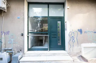 a green door on a building with graffiti on it at Top sightseeing 3rd floor studio on a paved road! in Athens