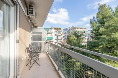 a balcony with a chair and a table on it at Top sightseeing 3rd floor studio on a paved road! in Athens