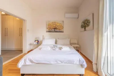 a bedroom with a white bed and a window at Top sightseeing 3rd floor studio on a paved road! in Athens
