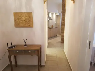 a hallway with a table and a painting on the wall at JOHN BEAUTY 50m2, METRO and ACROPOLIS 5' in Athens
