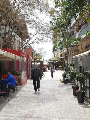 a man walking down a sidewalk in a city at JOHN BEAUTY 50m2, METRO and ACROPOLIS 5' in Athens