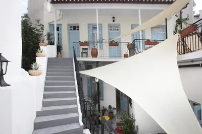a white house with stairs and potted plants at Live in Athens, THISEIO Historic House in Athens