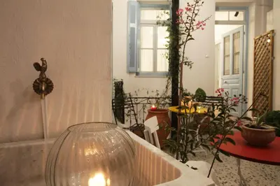 a living room with a table and a glass vase at Live in Athens, THISEIO Historic House in Athens