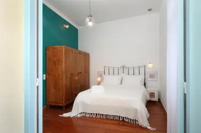a bedroom with a white bed and a green wall at Live in Athens, THISEIO Historic House in Athens