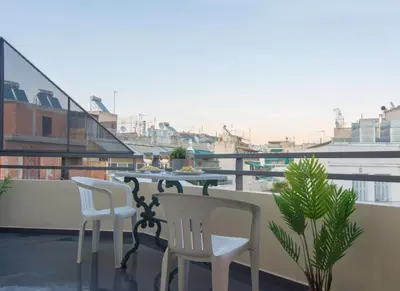 a balcony with a table and chairs on a roof at 5th flr Boho studio @ Exarheia w/ balcony in Athens