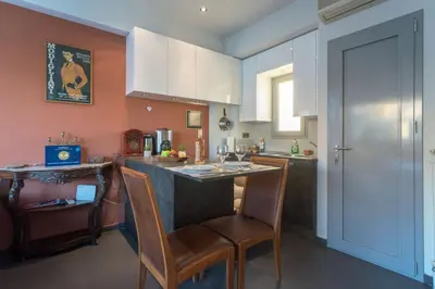 a kitchen with a bar with chairs and a table at 5th flr Boho studio @ Exarheia w/ balcony in Athens