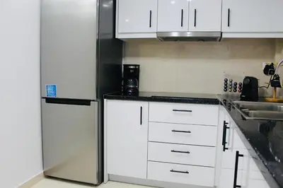 a kitchen with white cabinets and a refrigerator at Bright and Peaceful Apartment near Varkiza beach in Varkiza