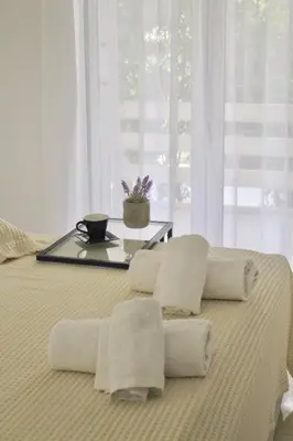 a bed with two pillows and a tray on it at Bright and Peaceful Apartment near Varkiza beach in Varkiza