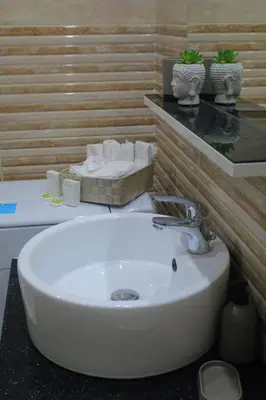 a bathroom with a sink with towels on a counter at Bright and Peaceful Apartment near Varkiza beach in Varkiza