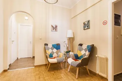 a living room with two chairs and a table at Museum of Modern Art Rooms in apartment, next to metro Suggrou Fix, walk to Acropolis in Athens