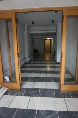an empty room with a checkerboard floor and a hallway at Museum of Modern Art Rooms in apartment, next to metro Suggrou Fix, walk to Acropolis in Athens