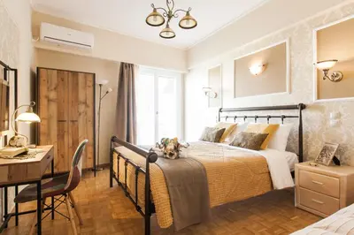 a bedroom with a large bed and a desk and a table at Museum of Modern Art Rooms in apartment, next to metro Suggrou Fix, walk to Acropolis in Athens
