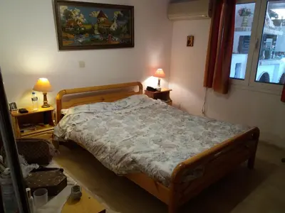 a bedroom with a bed and two lamps and a window at Aliki House in Porto Rafti