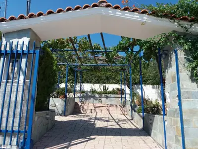 an entrance to a garden with a blue gate at Aliki House in Porto Rafti